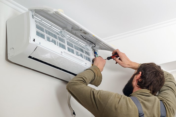 Man installing a wall-mounted heat pump